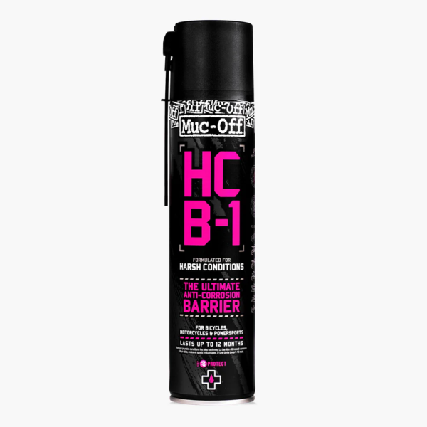 A tall black spray bottle of Muc-Off HCB-1 is shown with big pink font on the front describing it as a Harsh Condition Barrier