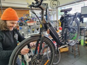 A mechanic is shown working on a bicycle in for an Essential E-Bike Service at Abbotsford Cycles