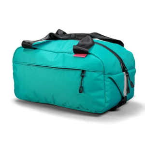 A bright Teal green little bicycle suitcase known as the Swift Industries Sugarloaf Basket Bag is shown with black seat-belt top handles & black zippers