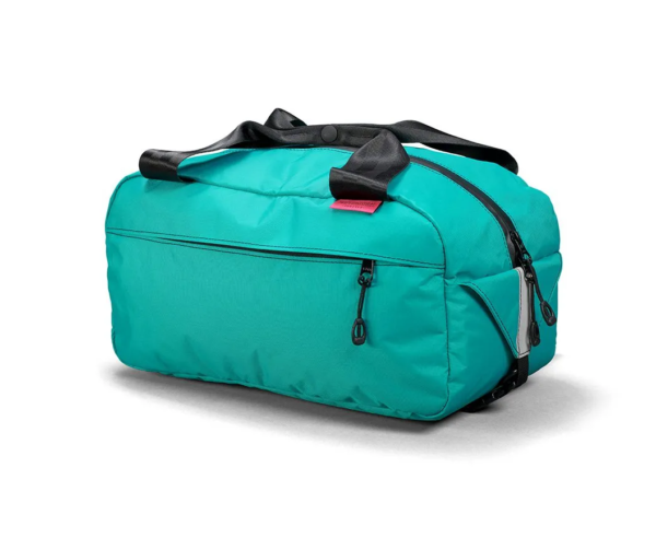 A bright Teal green little bicycle suitcase known as the Swift Industries Sugarloaf Basket Bag is shown with black seat-belt top handles & black zippers