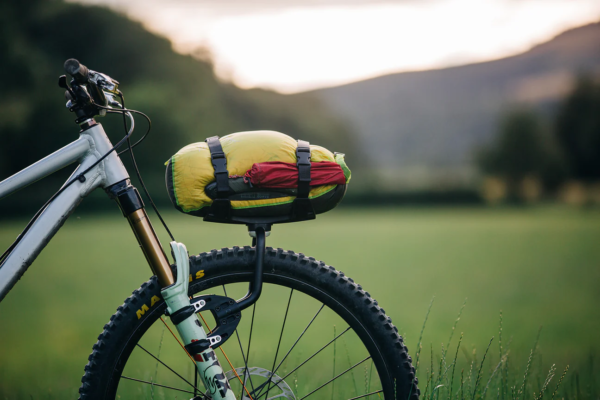 An Aeroe Spider Front Rack is shown fitted to a suspension fork with a dry bag strapped on to a Cradle on the rack